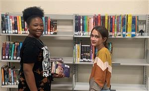 Library aides holding books